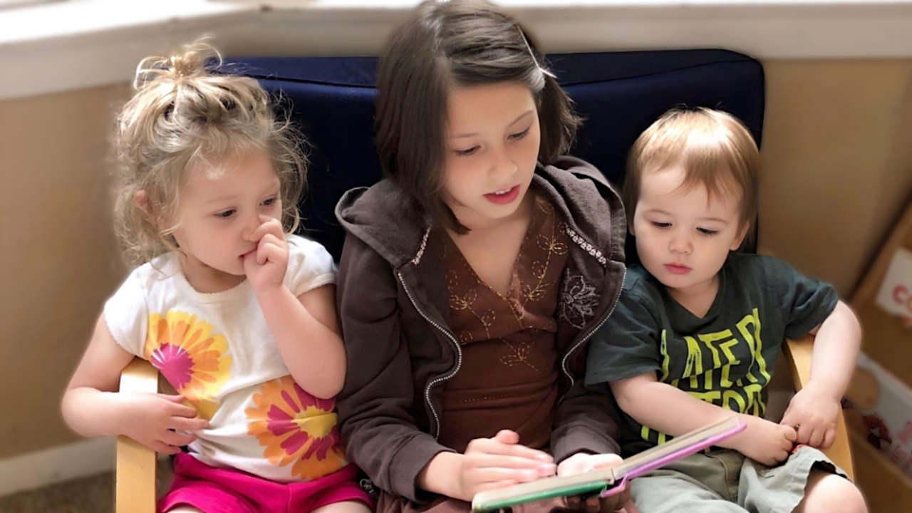 Amy & Kids Co. - Older Girl Reading to Younger Children
