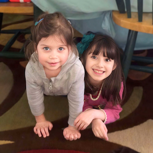 Two Girls Under a Table - Child Care Articles