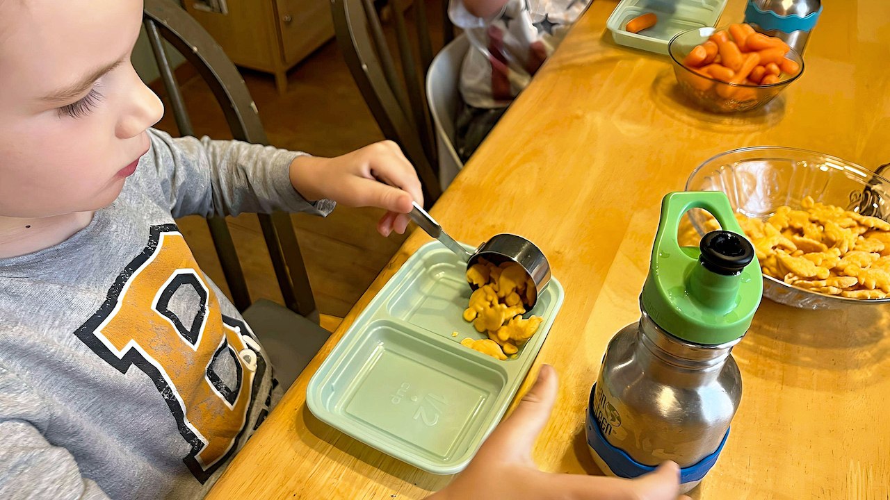 Child Care Nutrition - Boy Serving Himself Cheesy Crackers