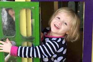Child Care App Girl Smiling in Play House Doorway