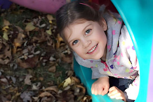 Girl Smiling Out of Slide