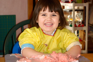 Child Care FAQ - Girl Playing in Colored Shaving Cream