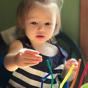 Daily Learning Activities - Girl Putting Beads on Chenille Stems