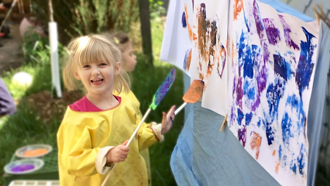 Parent Partnership - Girl in Piggy Tails Painting with Fly Swatter on Sheet