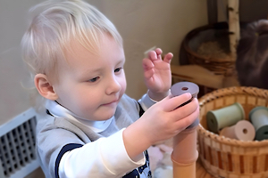 Quality Child Care Program - Boy Stacking Wooden Spools