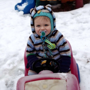 Severe Weather Policy - Toddler in Snowsuit Sitting in Play Car
