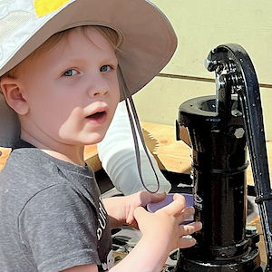 Sun Safety = Boy in Sun Hat at Pump