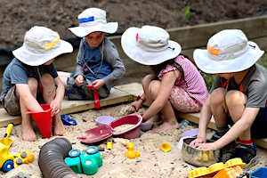 Sun Safety - Children in Sun Hats Playing in Sandbox