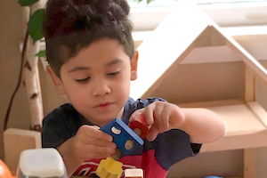 Wait List FAQ - Boy Playing with Blocks